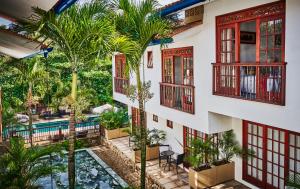 an exterior view of a building with a pool and palm trees at Lombok Hotel & SPA antes Hotel Casablanca in Guaduas +28 photos