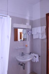 a white bathroom with a sink and a mirror at Michael Apartments in Rethymno