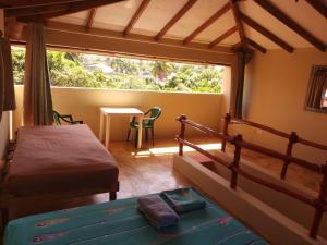 a bedroom with a bed and a table and a window at YES PAPA! Rooms at 100m from the beach! in Las Galeras