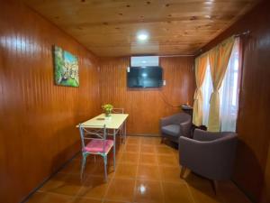 a room with a table and chairs and a television at Depto N°4 Temuco Centro in Temuco