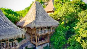 an aerial view of a building with thatched roofs at Elang Hillside Bamboo Villas in Labuan Bajo