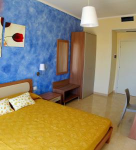 1 dormitorio con cama y pared azul en B&B La Sciuscitta, en Morciano di Leuca
