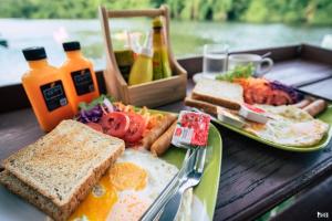 a table with a plate of breakfast foods and drinks at ชอว์ งาทอง รีสอร์ต Chor Ngar Thong Erawan Kanchanaburi in Tha Kradan