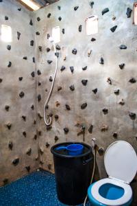 ein Bad mit einer Felswand und einem WC in der Unterkunft BB Dorm Koh Kood in Ko Kood