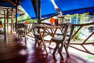 a group of tables and chairs with a blue umbrella at BB Dorm Koh Kood in Ko Kood