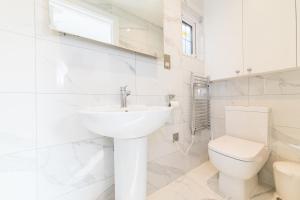 a white bathroom with a sink and a toilet at Elimonn Bloom in Kent