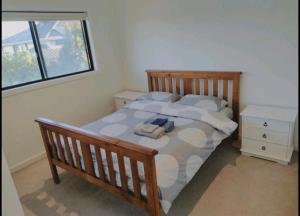 a bedroom with a wooden bed with towels on it at Not entire house!! Cozy two bedrooms with private bathroom and parking in Point Cook