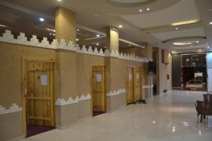 Pokój z korytarzem z drewnianymi drzwiami i pokojem z: w obiekcie Alwan apartment hotel w mieście Chamis Muszajt