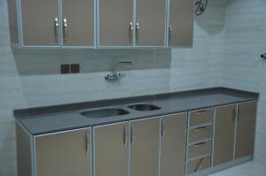 a kitchen with a sink and white cabinets at Alwan apartment hotel in Khamis Mushayt