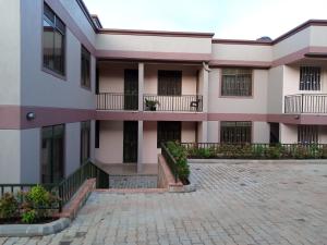 a building with balconies and a brick courtyard at Kaks apartments in Kampala