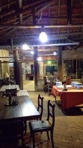 a dining room with tables and chairs in a building at Chalé Sonho Diniz 1 in Monte Verde