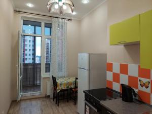 a kitchen with a refrigerator and a table and a window at Top Apartments Hollywood in Kazan