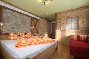 a bedroom with a bed and a brick wall at Hotel Humlerhof in Gries am Brenner +26 photos