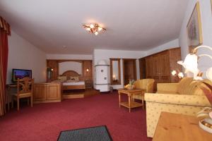 a living room with a couch and a kitchen at Hotel Humlerhof in Gries am Brenner