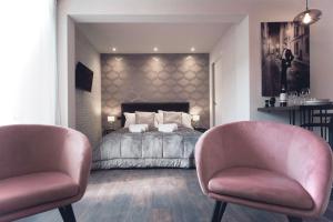 um quarto com uma cama e 2 cadeiras cor-de-rosa em S H E N K I N ChicLife Design Apt next to the Museum em Bérgamo