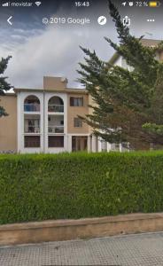 a building with a hedge in front of a building at Apartamento Portobello in Port de Pollensa