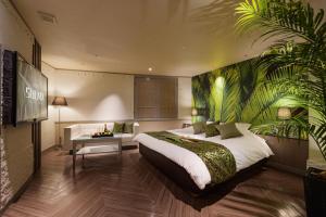 a hotel room with a bed and a palm tree mural at HOTEL SULATA GIFU HASHIMA (Adult Only) in Hashima