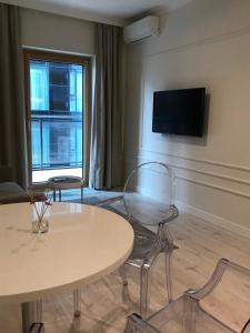 Pokój ze stołem, 2 krzesłami i telewizorem w obiekcie Mennica Residence Hotel Apartments w Warszawie