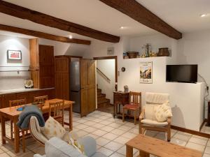 uma sala de estar com um sofá, uma mesa e uma cozinha em Well equipped village house close to historic centre - Pézenas em Pézenas