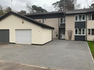 a house with a garage and a driveway at 5 Bed Camberley Airport Accommodation in Camberley