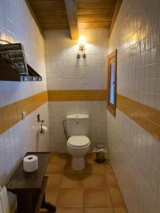 Baño pequeño con aseo y mesa en Casa Clemente II, en La Hiruela