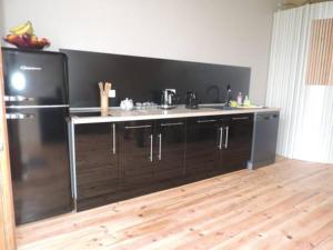 a kitchen with a black counter and a refrigerator at Gîte la mirabelle in Montazeau