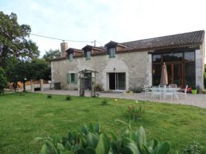 uma casa com um quintal com cadeiras e um pátio em Gîte la mirabelle em Montazeau