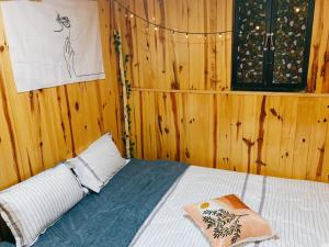 a bedroom with a bed with a wooden wall at EUDORA HOUSE 2 in Da Thien