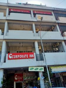钱德加尔HOTEL CORPORATE INN的前面有公司旅馆标志的建筑