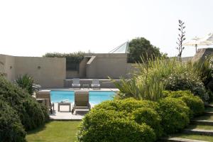 a swimming pool in a yard with some bushes at Le Fort de l'Océan in Le Croisic