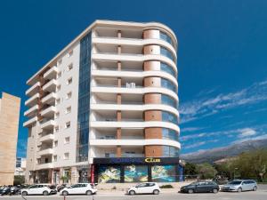 a tall white building with cars parked in front of it at Seaside Rest Apartments in Budva