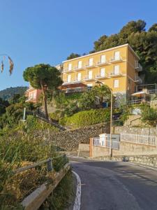 a building on a hill next to a street at Hotel Pineta in Laigueglia