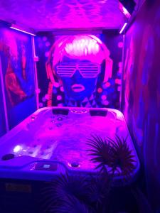 jacuzzi en una habitación con luces púrpuras en Gites N Spa, en Tourcoing