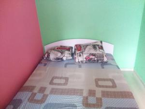 a small bedroom with a bed with two pillows at Мегацентр in Chernihiv