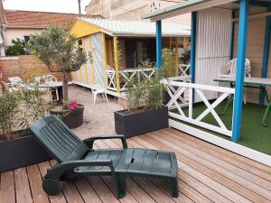 ポルティラーニュにあるLes Chalets la Plage - Etape Vacancesの木製デッキ(家屋付)の緑の椅子
