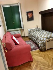 a bedroom with a red couch and a bed at Cà del Cerin in Trivero