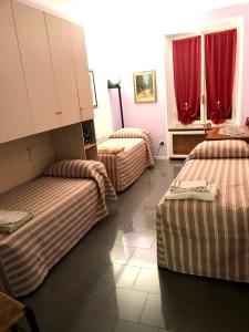 a hotel room with two beds and red curtains at Cà del Cerin in Trivero