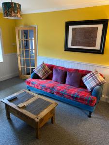 un soggiorno con divano e tavolino da caffè di Holly Cottage a Glencoe