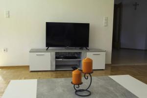 a living room with a flat screen tv on a entertainment center at Schöne helle Ferienwohnung in Waldnähe in Berching