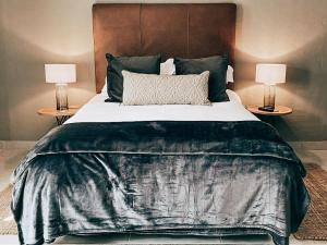 1 dormitorio con 1 cama grande y 2 mesitas de noche en Battiss Guest House, en Pretoria