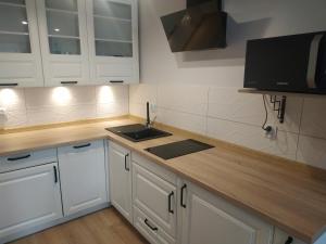 a kitchen with white cabinets and a sink at apartament Forest Karpacz in Karpacz