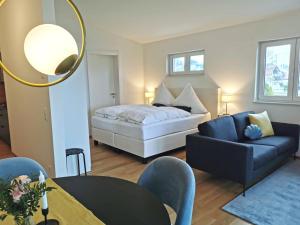 ein Wohnzimmer mit einem Bett und einem Sofa in der Unterkunft MAISON AMAND - Am See mit Privatstrand in Immenstaad am Bodensee