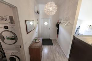 a hallway with a washer and dryer and a chandelier at The Boathouse in Streymnes