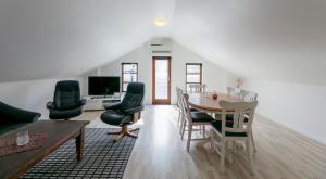 a living room with a table and chairs at The Boathouse in Streymnes