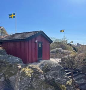 a redshed with two flags on top of a rock at Marstrand in Marstrand