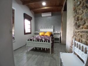 - une chambre avec un lit et des oreillers jaunes dans l'établissement Albergue la Medina de Camponaraya, à Camponaraya