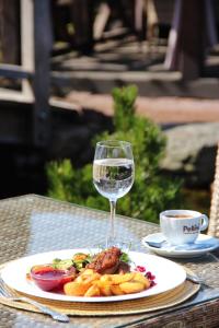 un plato de comida y una copa de vino en una mesa en Senoji užeiga en Molėtai