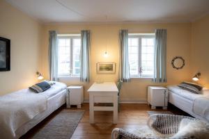 Habitación con 2 camas, mesa y ventanas. en Inspiration Center Denmark, Guesthouse en Maribo