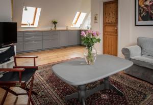 una sala de estar con un jarrón de flores sobre una mesa en Inspiration Center Denmark, Guesthouse en Maribo