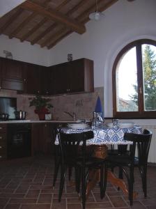 a kitchen with a table with black chairs and a window at Casa Vacanze Porta Vecchia in Montalcino